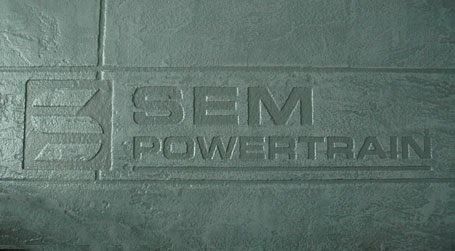 Image of the SEM Powertrain logo embossed in concrete - at our facility in Pickering, Ontario, Canada.